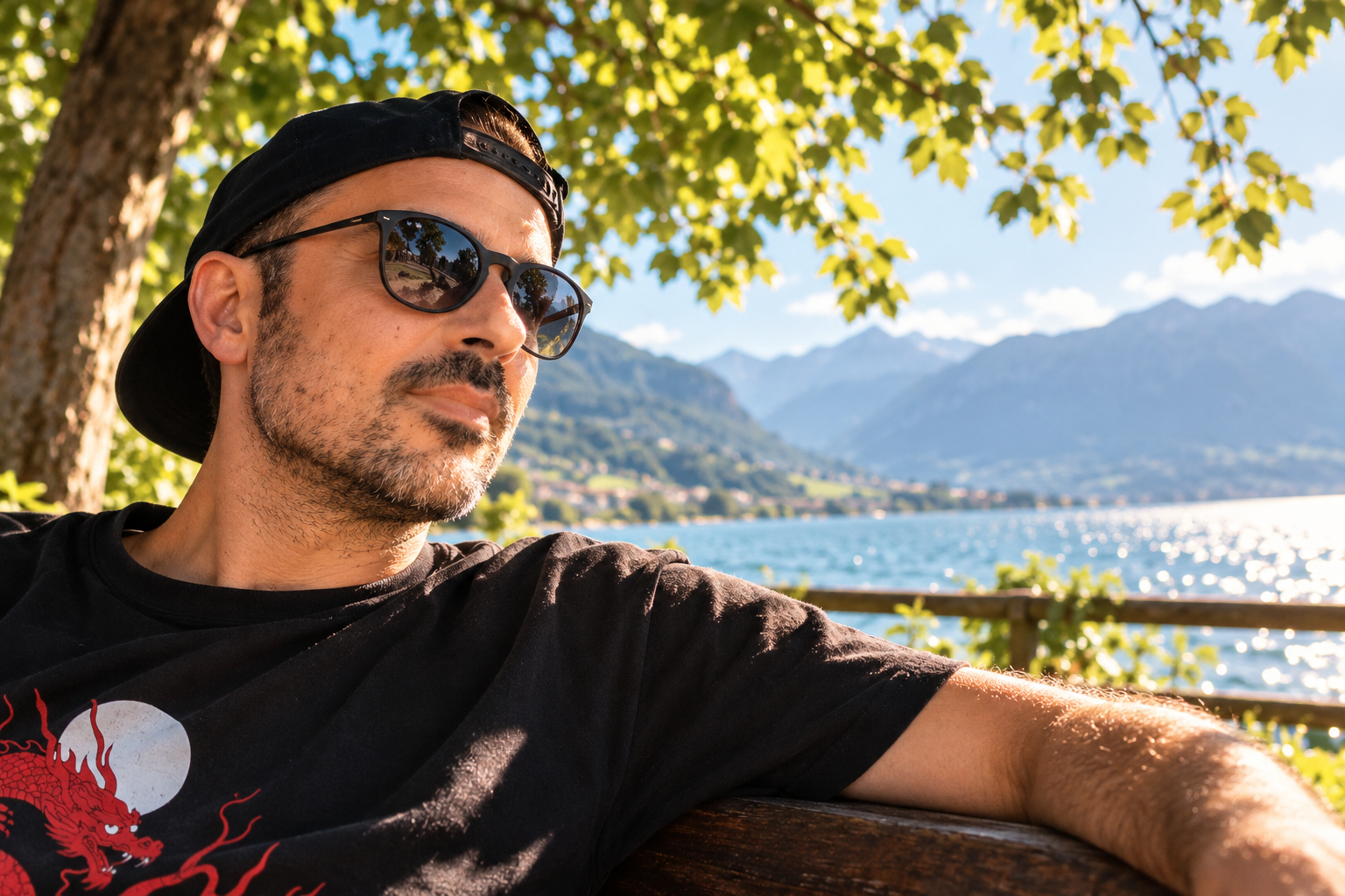 Michele all’aperto in una giornata luminosa, con cappellino nero e occhiali da sole